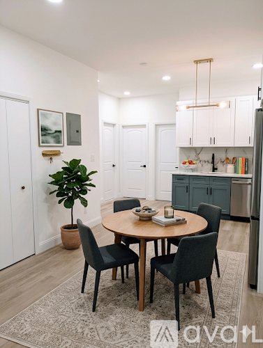 A dining room with a round table and chairs.