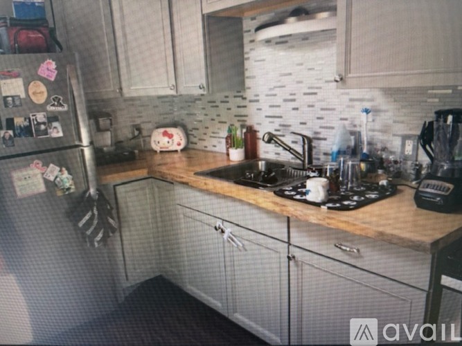 A kitchen with a refrigerator covered in magnets, a stove, and a sink.