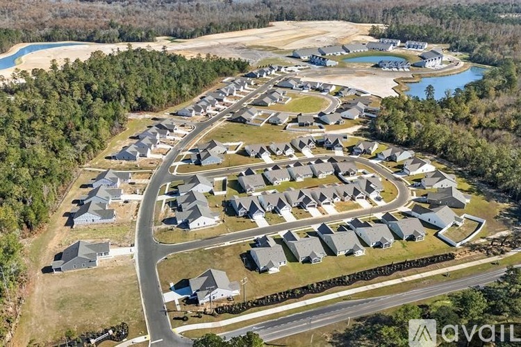 A bird's eye view of a residential area with houses and a lake.