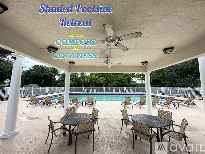 A shaded poolside retreat with tables and chairs.
