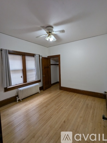 A room with wooden floors and a ceiling fan.