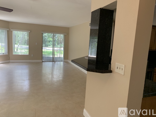 A spacious living room with a black countertop and large windows.