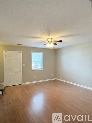 A room with a ceiling fan and a door.
