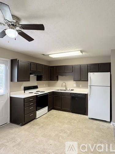 A kitchen with black cabinets and a white refrigerator.