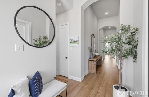 A living room with a white couch and a round mirror on the wall.