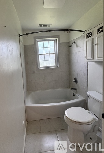 A bathroom with a tub, toilet and sink.
