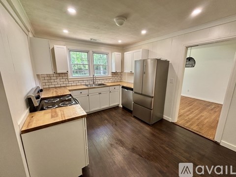 A kitchen with white cabinets and a wooden countertop.