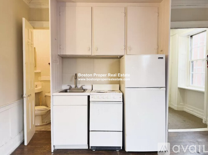 A kitchen with white appliances and cabinets is for sale.