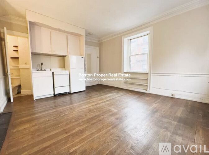 A spacious room with wooden flooring and white cabinetry is available for rent.