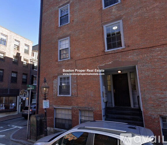A brick building with a car parked in front of it.