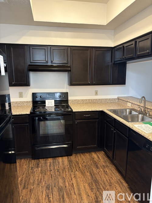 A kitchen with black cabinets and a white stove top oven.