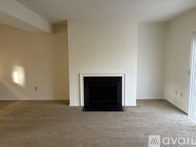 A living room with a fireplace and carpeted floor.