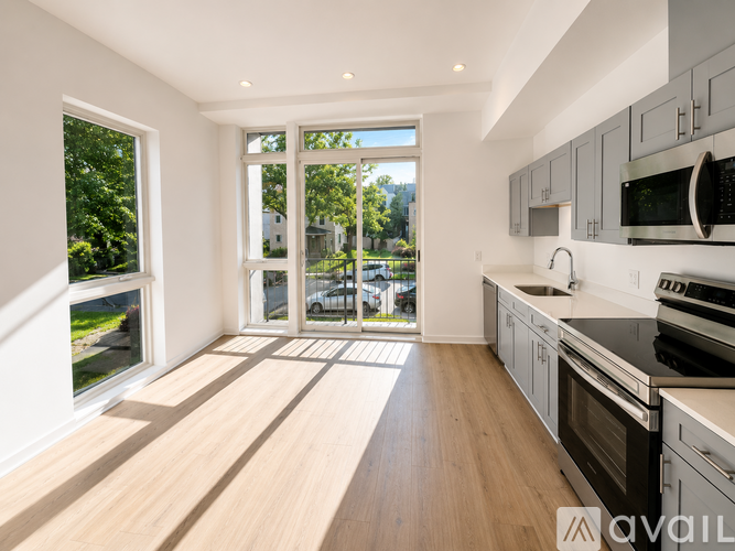 A modern kitchen with a view of the street outside the window.