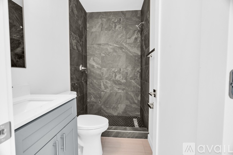 A bathroom with a toilet, sink, and shower.