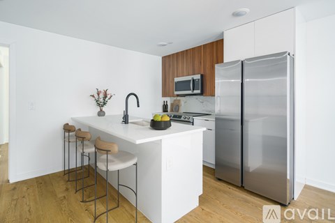 A kitchen with a white counter and a refrigerator.