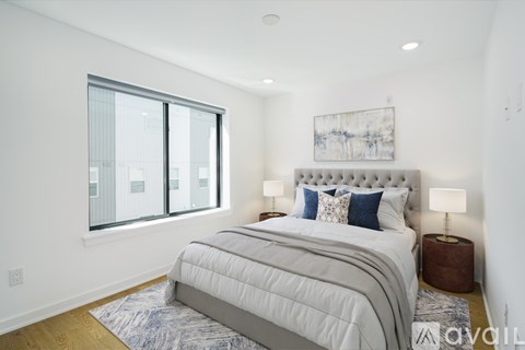 A bedroom with a large bed and a window overlooking a cityscape.