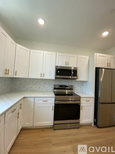 A kitchen with white cabinets and a stainless steel refrigerator.