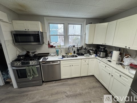A kitchen with white cabinets and a black stove top.