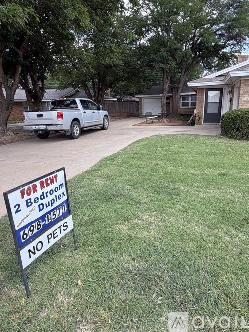 A For Rent sign is in the front yard of a house.