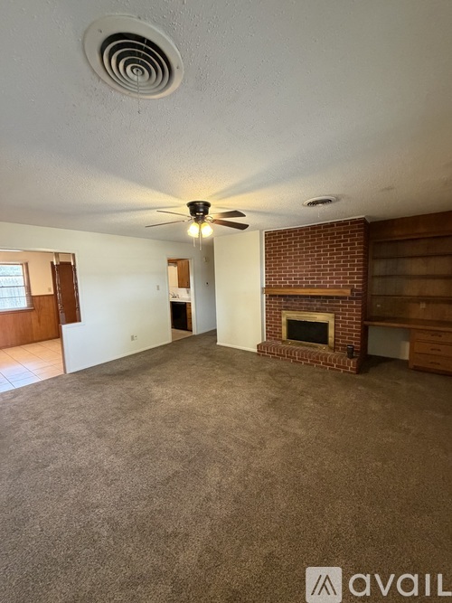 A living room with a fireplace and a ceiling fan.
