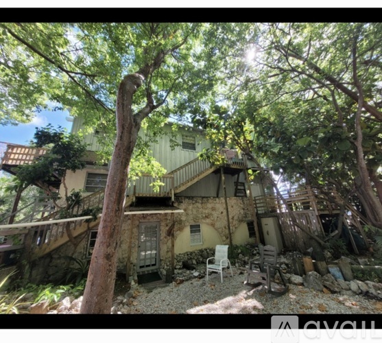 A house surrounded by trees with a balcony.