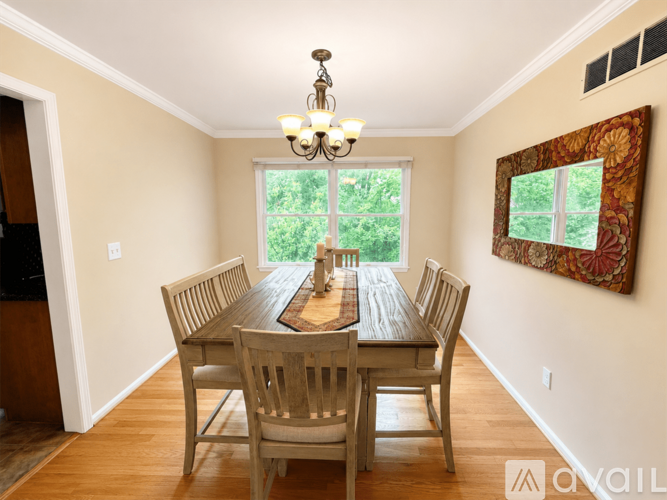 A dining room with a wooden table and chairs.