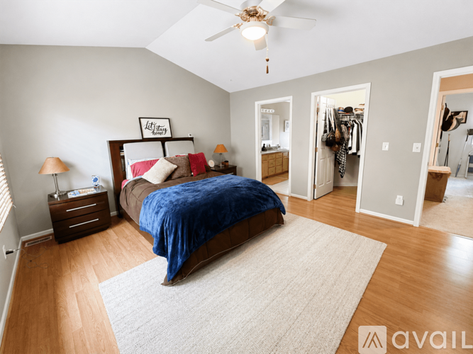 A bedroom with a bed, dresser, and a ceiling fan.