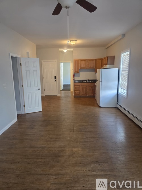 A spacious kitchen with wooden cabinets and a white refrigerator.