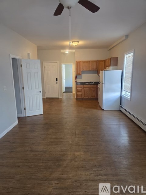 A spacious kitchen with wooden cabinets and a white refrigerator.