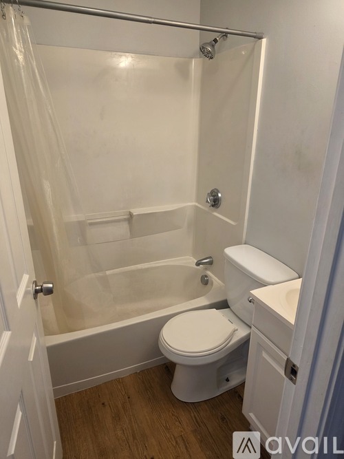 A white bathroom with a toilet, sink, and shower.