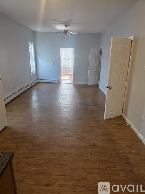 A room with wooden floors and a ceiling fan.