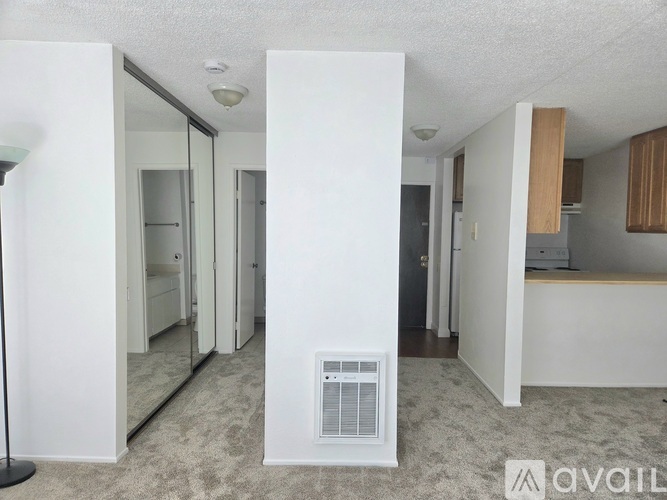 A well-lit, spacious living area with a carpeted floor and a large window.