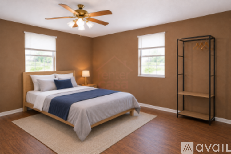 A bedroom with a bed, a ceiling fan, and a window.