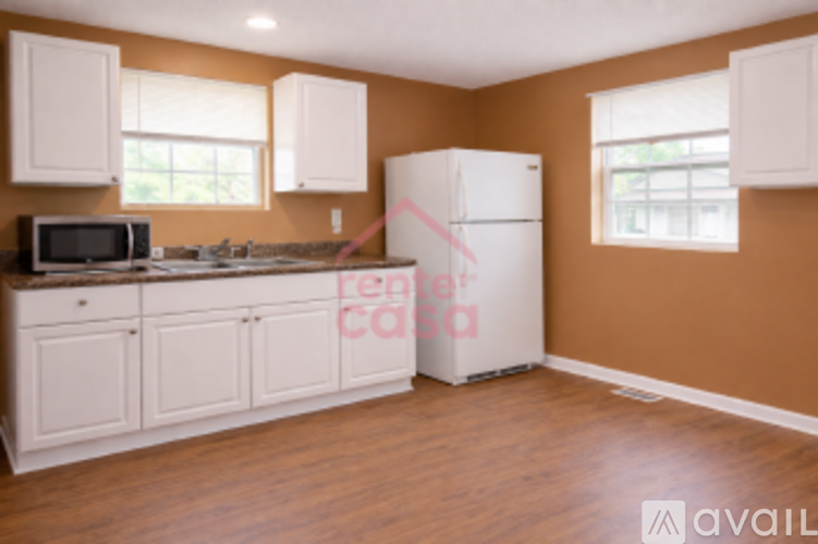 A kitchen with brown walls and white appliances.