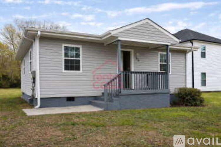 A house with a grey exterior and a porch with a railing.