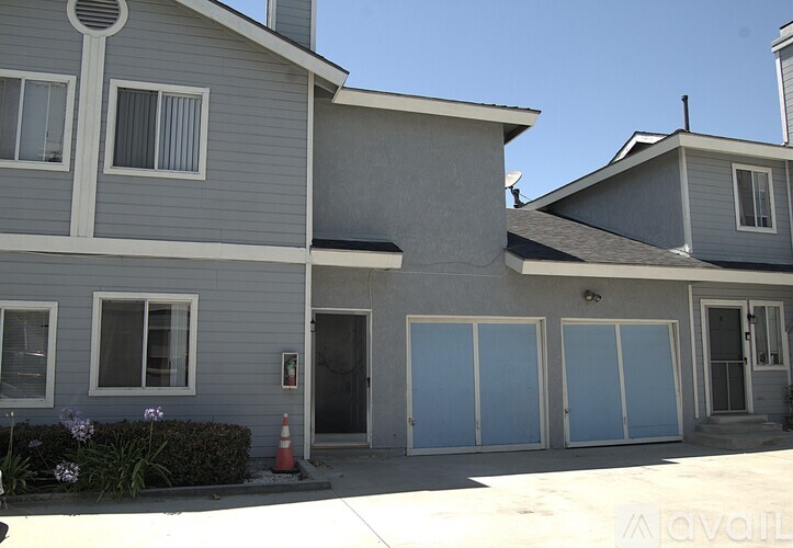 A grey house with a white door and windows.