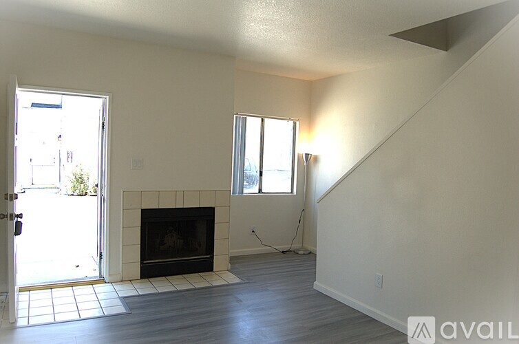A living room with a fireplace and a staircase.