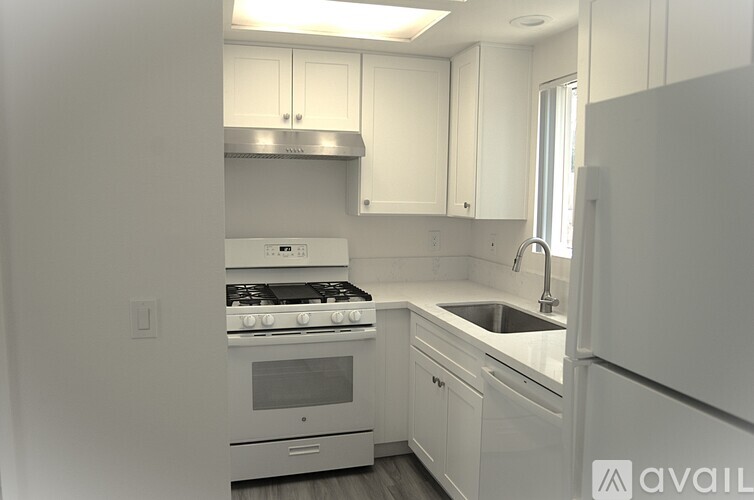 A kitchen with white cabinets and appliances.