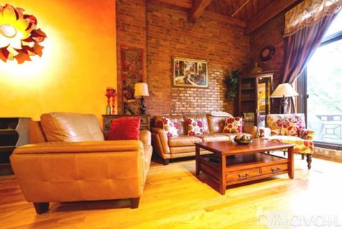 A living room with a brown leather couch and a wooden coffee table.