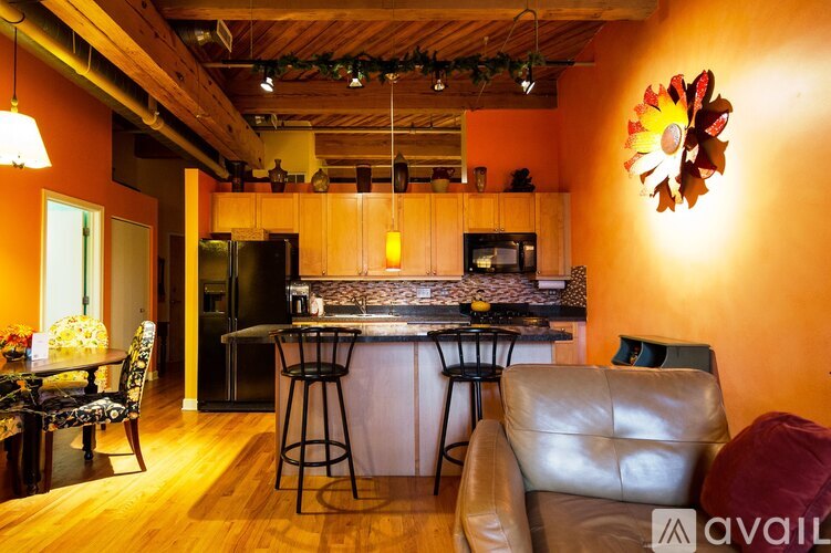 A kitchen with a bar and a dining table with chairs.