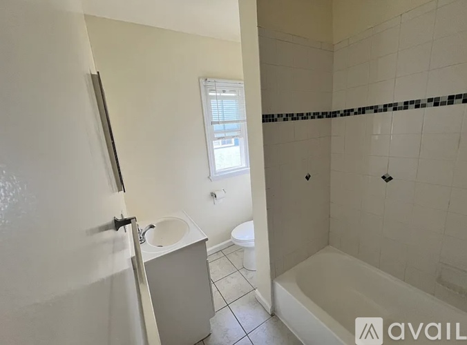 A bathroom with a white tub, sink, and toilet.