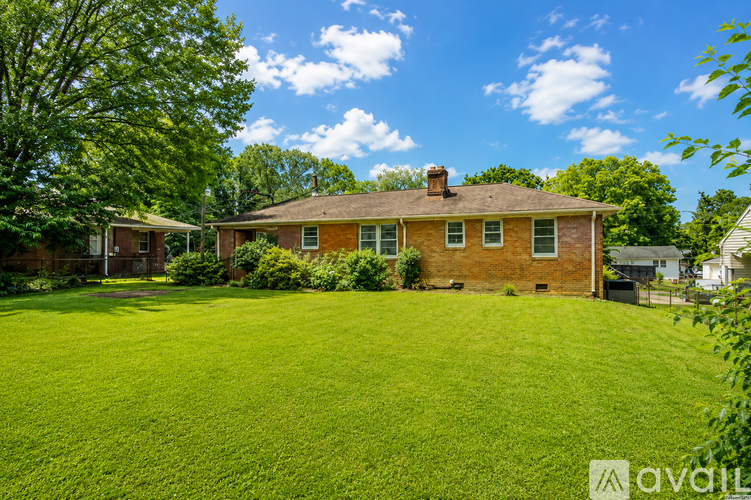 A house with a green lawn in front of it.