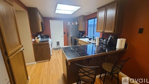 A kitchen with wooden cabinets and a black countertop.