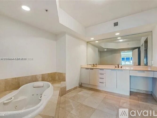 A spacious bathroom with a large tub and double sinks.