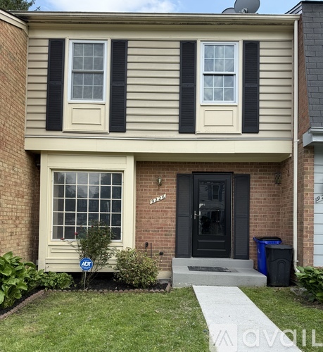 A house with a black door and a small garden in front.
