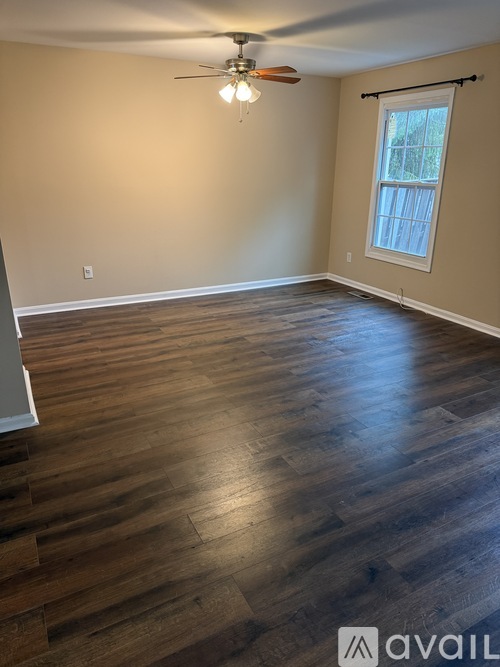 A room with wooden flooring and a ceiling fan.