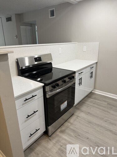 A kitchen with a black stove top oven and white cabinets.