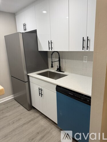 A kitchen with a white counter top and a blue dishwasher.