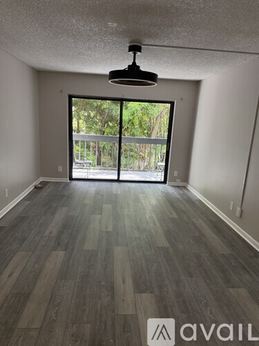 A room with a large window and wooden flooring.