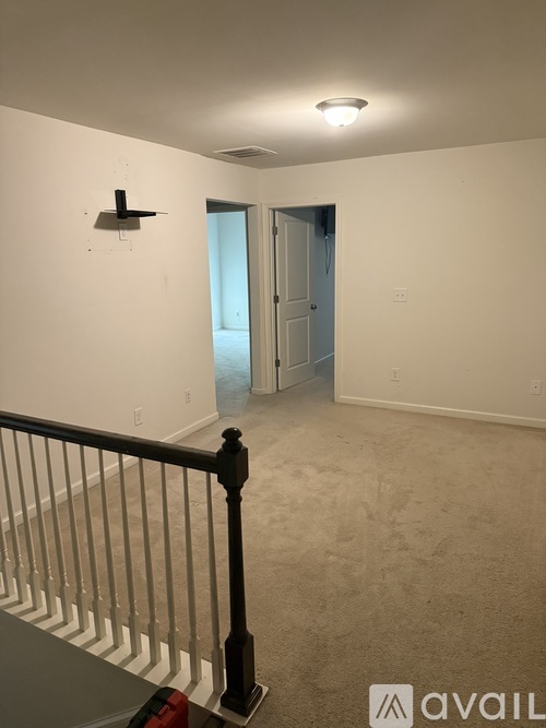 A room with a white wall and a black shelf on it.